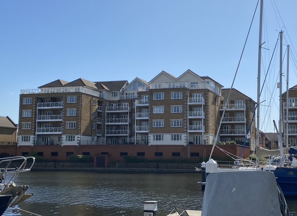 IMG_25_43_largejpg - Sovereign Estates Sovereign Estates Brick apartment complex along a calm canal with balconies under a clear blue sky and anchored sailboats nearby 2026 Brick apartment complex along a calm canal with balconies under a clear blue sky and anchored sailboats nearby