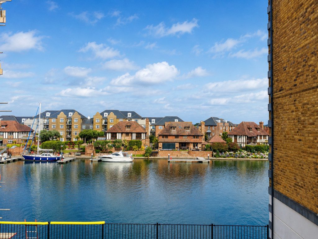 IMG_25_48_largejpg - Sovereign Estates Sovereign Estates Calm canal with moored boats and a row of brick townhouses under a blue sky 2026 Calm canal with moored boats and a row of brick townhouses under a blue sky